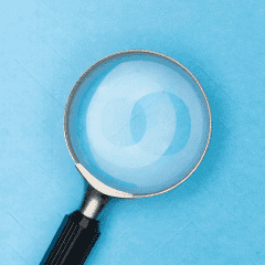 A magnifying glass above a light blue background
